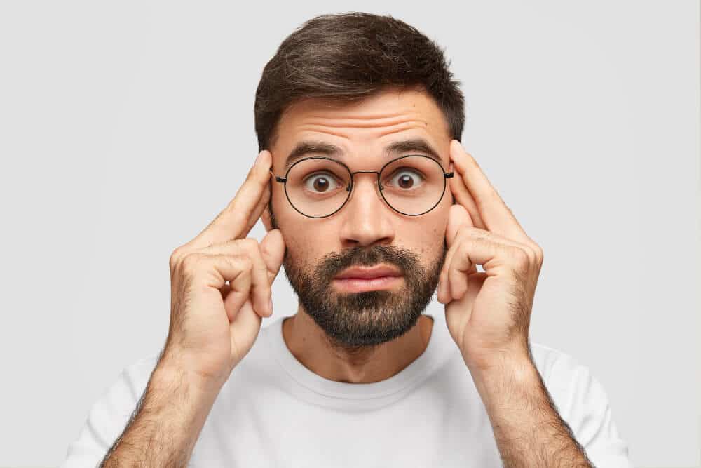 Man pointing to his head showing negative mindset